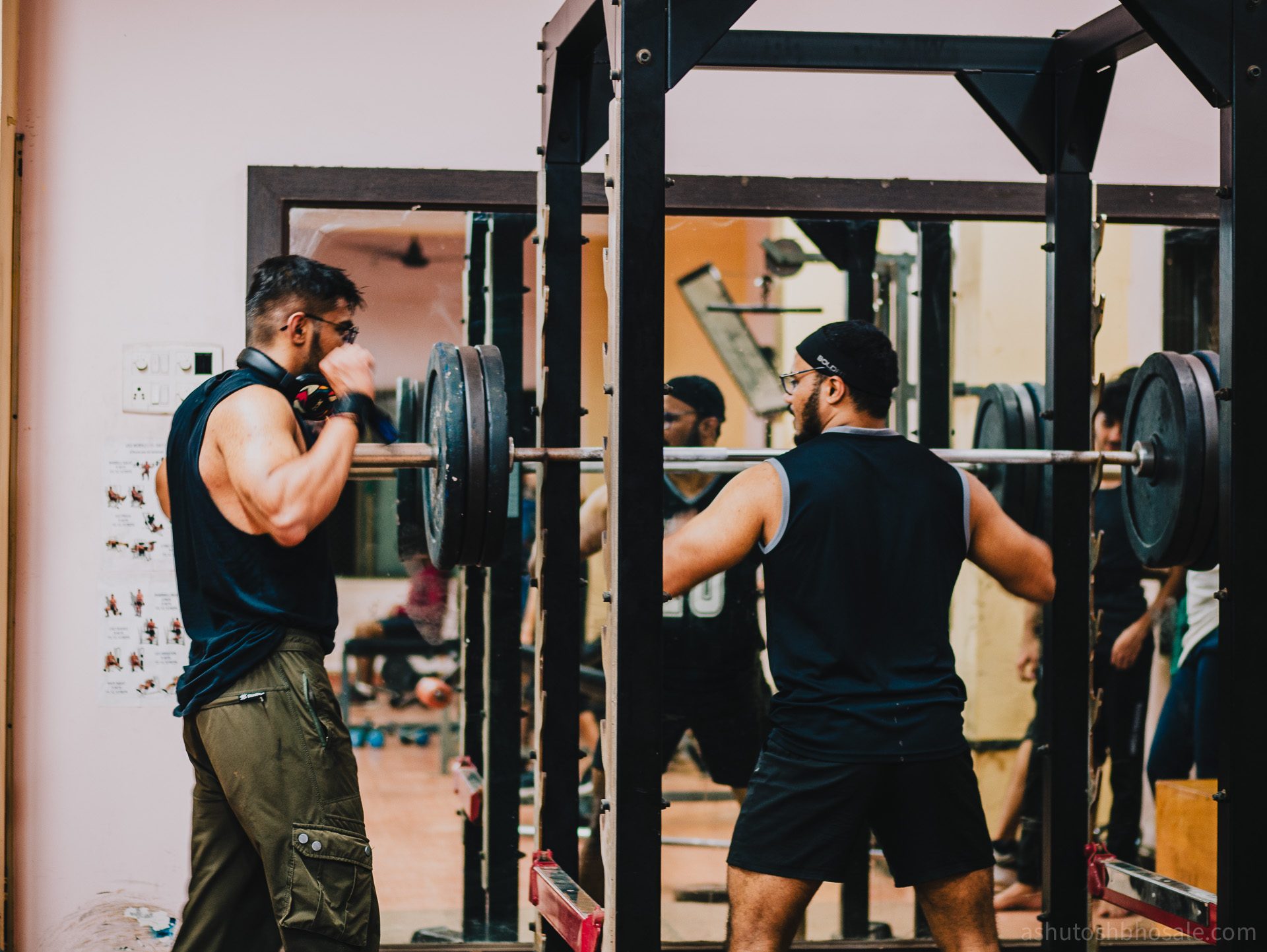 Two brothers talking at the squat rack.